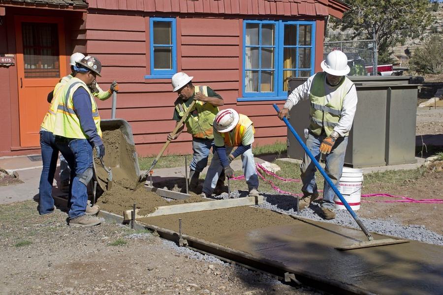 Crew pouring and leveling a concrete walk